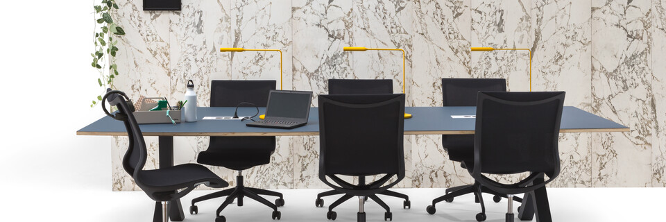 Gispen TEAM Design conference table with anthracite legs and frame with blue tabletop and black Turn chairs styled with marble backpanel front view