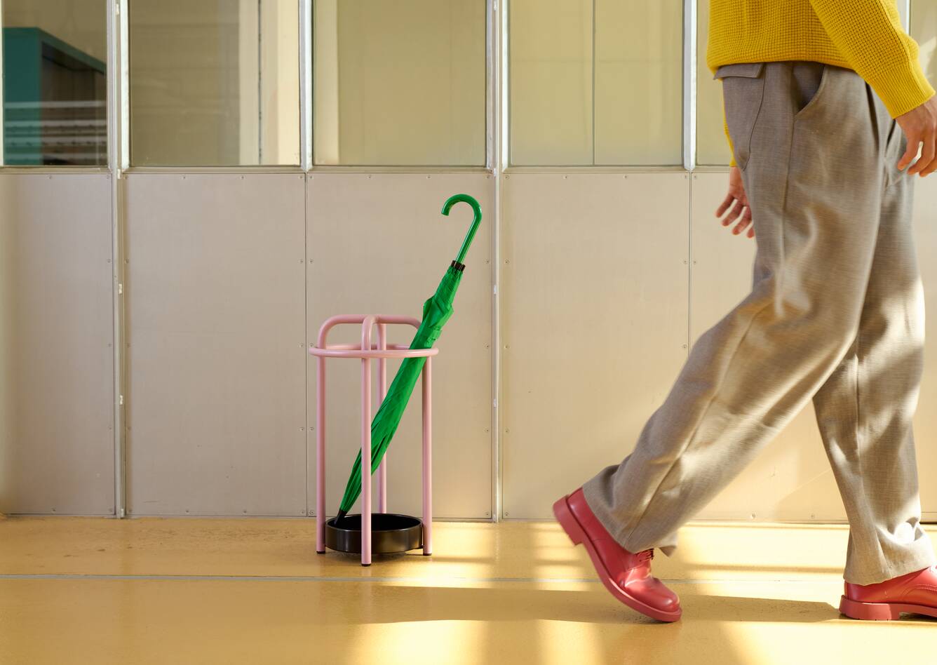 Gispen Classics 1017 umbrella stand in light purple and green umbrella with walking male model coffee roastery at Van Nelle factory front view