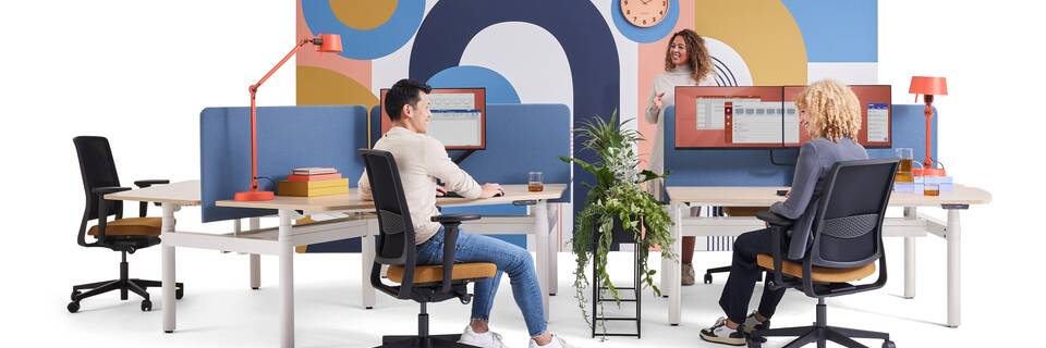 Gispen TMNL Round sit stand trio and dual workstation with oak tabletops and blue S25 screens styled with ZINN office chairs and models front view