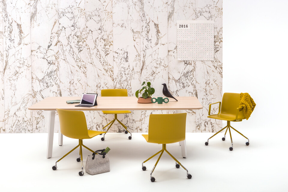 Gispen TEAM Classic conference table with white frame and oak tabletop and yellow Nomi Work chairs in front of marble backpanel front view
