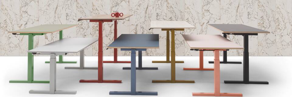 Gispen TMNL 7 single workstations in different colours in front of marble backpanel with red dombo cup right side view