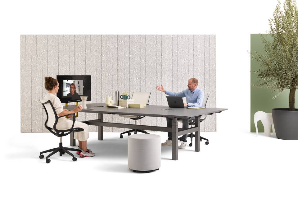 Gispen TMNL Agile table in dark grey with grey tabletop and backpanels with models with Turn chair and grey Asido pouf styled front right view