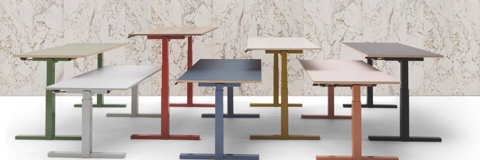 Gispen TMNL 7 single workstations in different colours in front of marble backpanel right side view