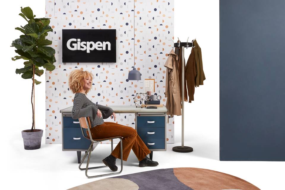 Gispen 7864 Kleurodesk desk in light grey with blue drawers with 113 chair and 9807 coat stand styled with female model in front of wall front view