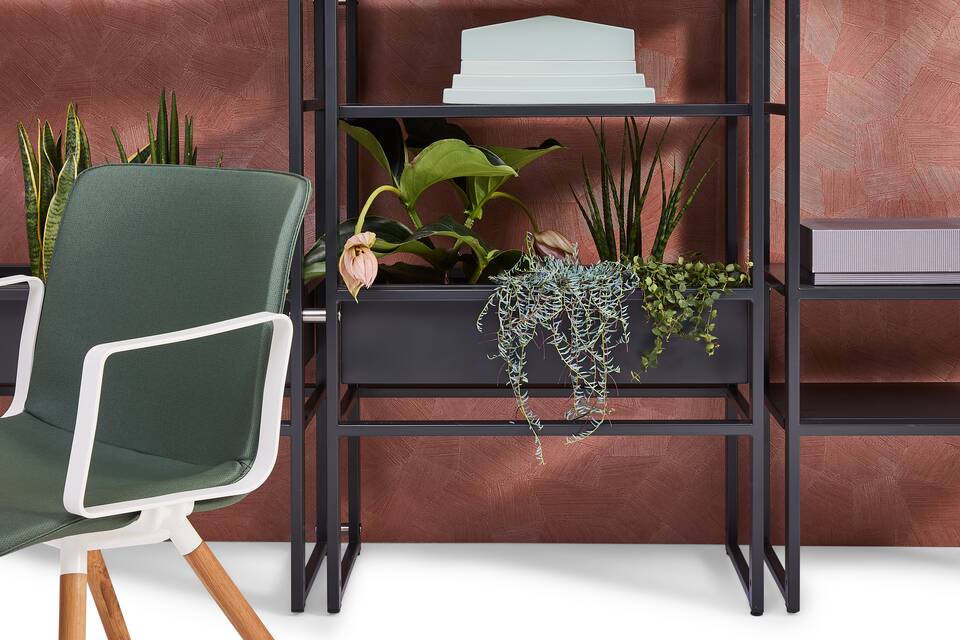 Gispen CIMO shelving unit in black with plants and white NOMI Wood with green upholstered cover in front of backpanel front view