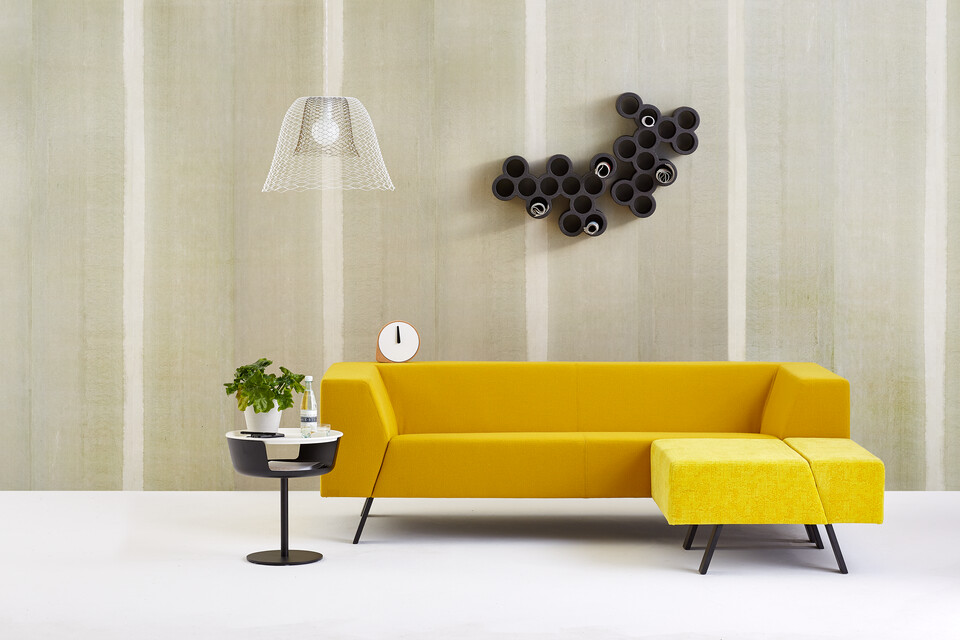 Gispen Sett sofa with yellow upholstery and Asy sidetable with Slingerlamp pendant lamp with plant in front of light green background front view