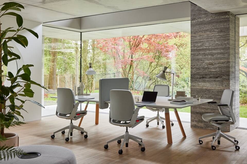 Ahrend Remode office chairs in grey and an Aero bench in a colaborative setting front right view