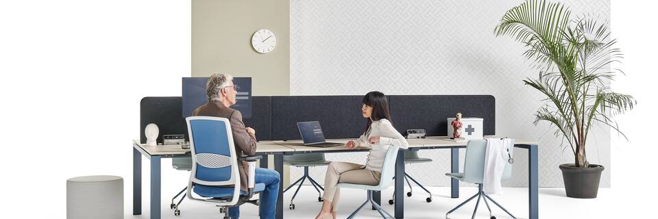 Gispen IC bench in blue with beech tabletop and ZINN office chair with NOMI Work chairs and grey Asido pouf with models and backpanels front left view