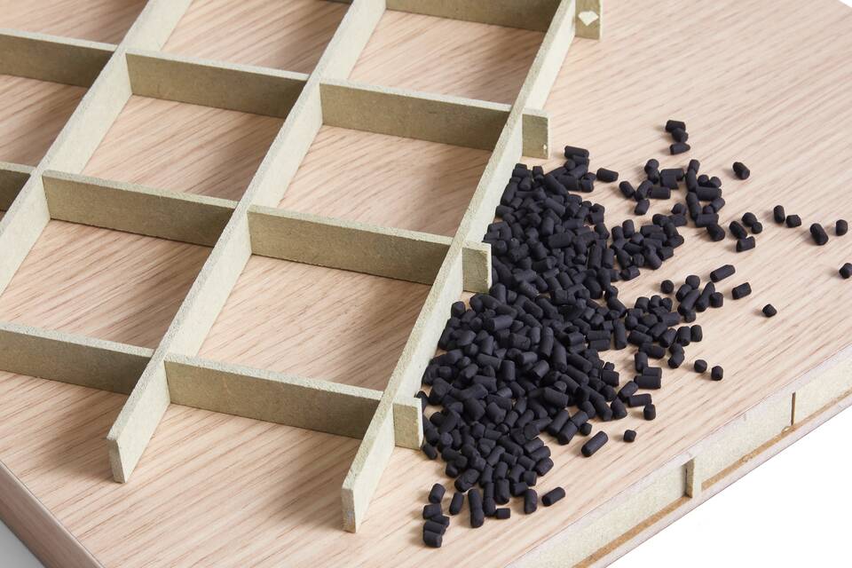 Ahrend raw materials of carbon granulates and Greengridz core on top of oak tabletop front top left detail view
