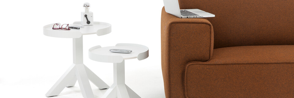 Gispen Dukdalf round small and large side tables in white with Switch table lamp next to brown sofa with laptop on it front view