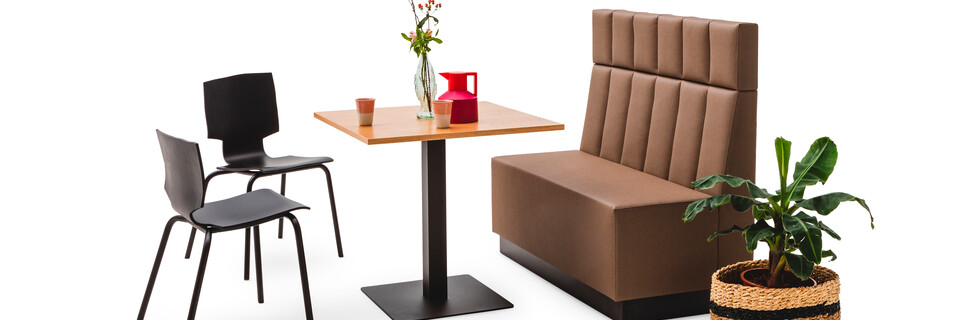 Gispen JUNA Single high trainbench upholstered in brown with black KOLM column table and 2 black More or Less chairs front right view