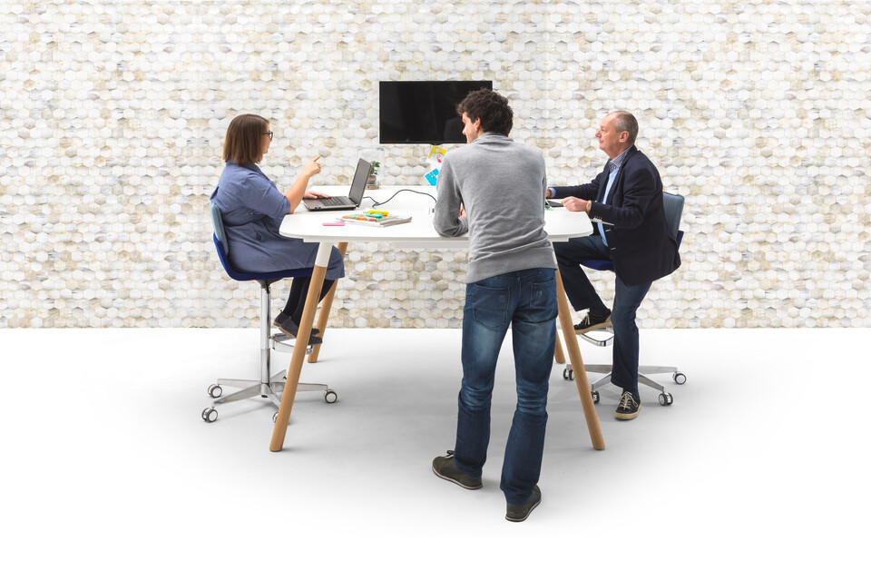 Gispen TEAM Wood round high conference table with oak legs and white frame and tabletop with blue Triennial Work High chairs and people and Beehive backpanel