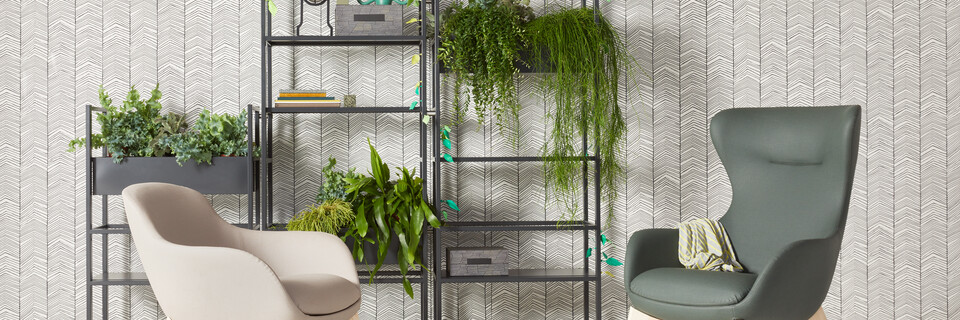 Gispen CIMO shelving unit in black with planters and Queen Low L14 armchair upholstered in beige and Queen High L14 green in front of wall front view