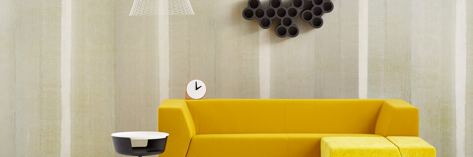 Gispen Sett sofa with yellow upholstery and Asy sidetable with Slingerlamp pendant lamp in front of light green background front view