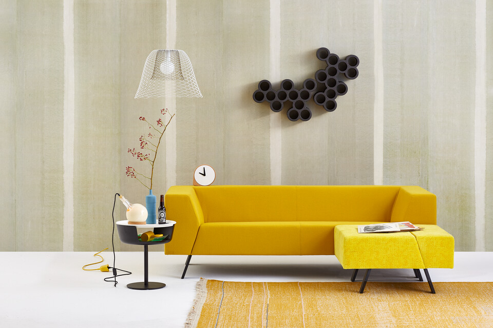 Gispen Sett sofa with yellow upholstery and Asy sidetable and dombo cup with Slingerlamp pendant lamp and carpet in front of light green background front view