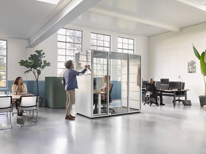 Ahrend Switch and Zinn with Concentration Corner and Qabin with door closed and Balance with Ease desk and chair with models in a Hybrid working community setting