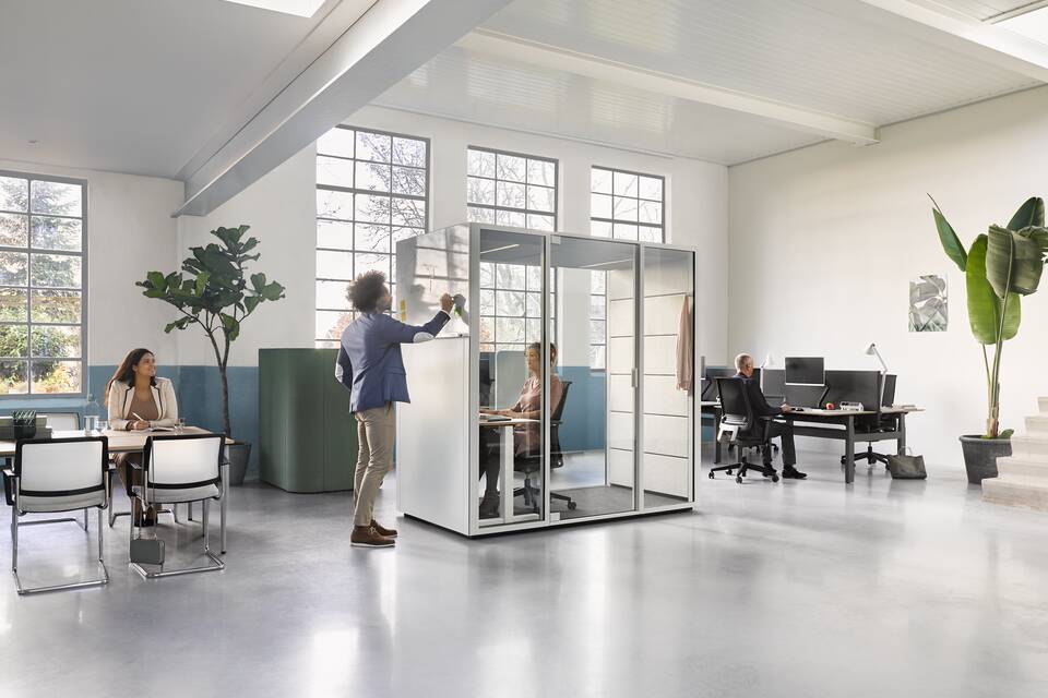Ahrend Switch and Zinn with Concentration Corner and Qabin with door closed and Balance with Ease desk and chair with models in a Hybrid working community setting