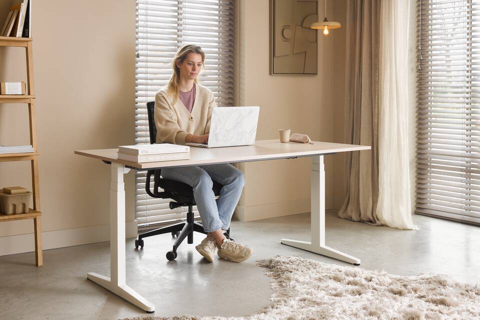 Ahrend Balance workstation in white with black ZINN Smart office chair in a work from home setting with female model interior view