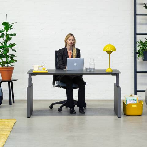 Royal Ahrend Balance workstation in grey with charcoal top and 2020 office chair with female model sitting front view