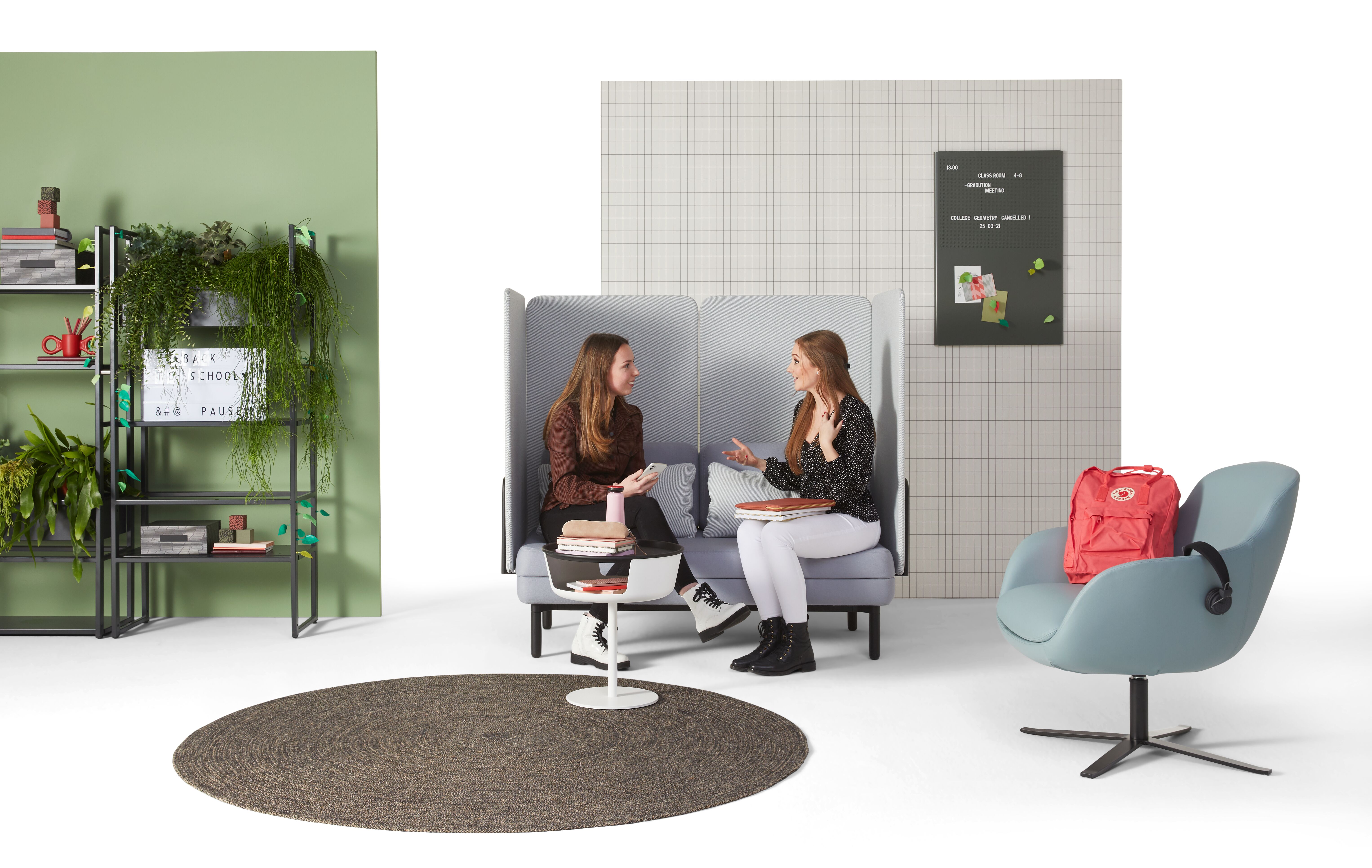 Gispen STEE sofa in black upholstered in grey and light blue with black CIMO Shelving Unit and light blue Queen Low armchair with female models front view