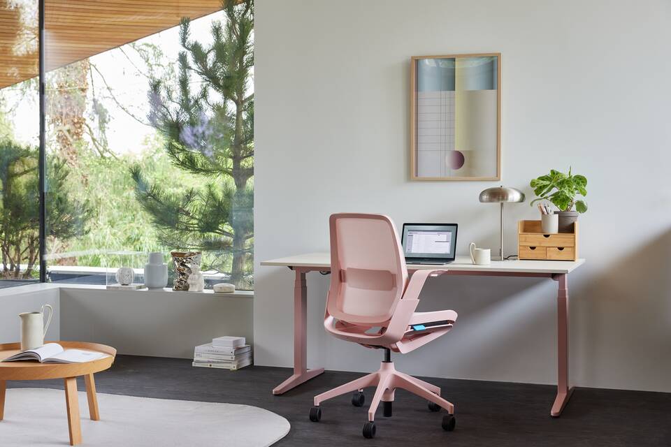 Ahrend Remode office chair in pink with removable lumbar support and balance solo workstation in a home setting right rear view