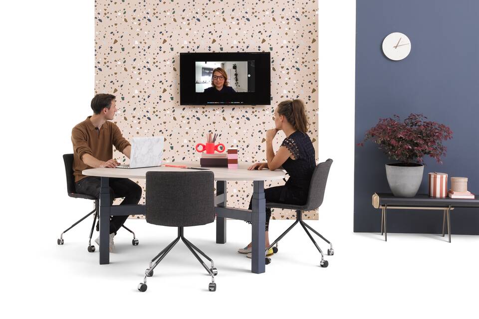 Gispen TMNL Agile 3 leg table in blue with grey beech tabletop with black NOMI work chairs and backpanels with models front right view