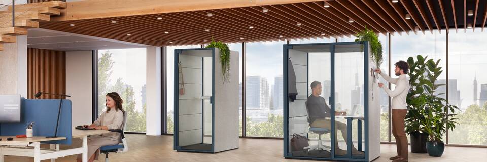 Ahrend Qabin Call and Work space in space in dark blue with models working in a vitalising workspace interior view