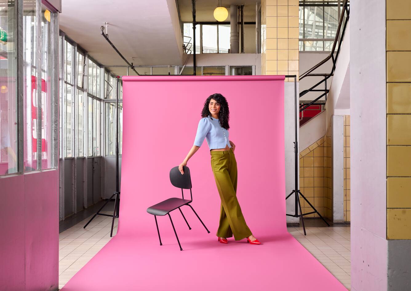 Gispen Classics 116 chair in black on purple backdrop with female model stairway at Van Nelle factory front right view