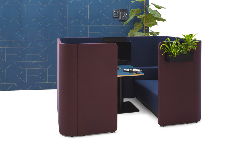 Gispen HUGG Duo couch XL upholstered in blue and black table and planters with presentation screenholder and blue backpanel front view