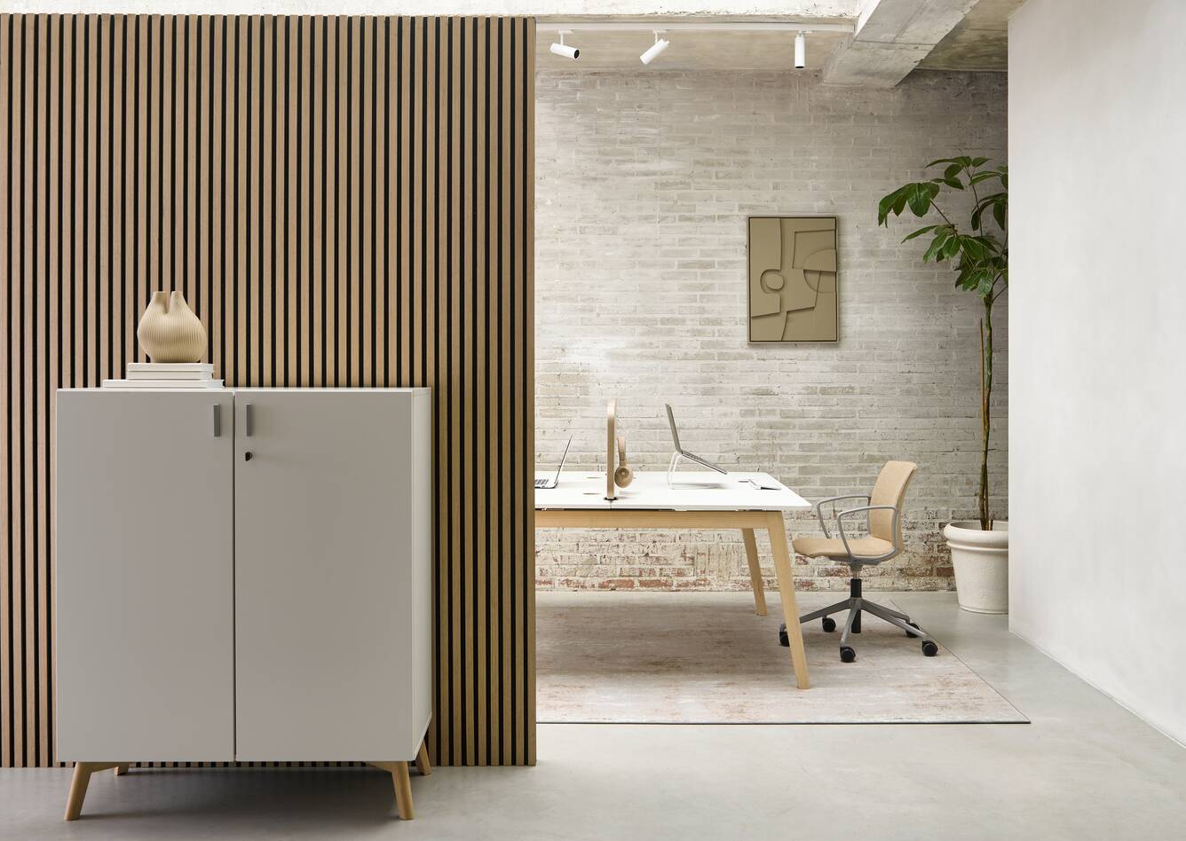 Techo Hyll cabinet in white with birch legs and Fount dual workstation in oak and white top with beige upholstered Well chair front view