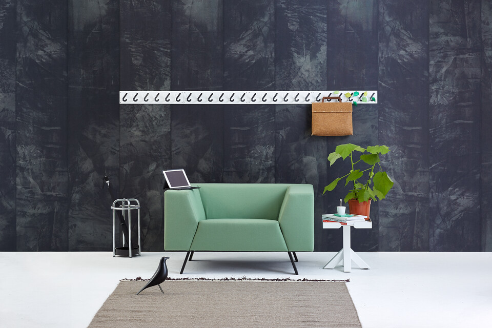Gispen Sett armchair with green upholstery and 1x6 coat rack and Dukdalf sidetable with grey backpack in front of black background front view