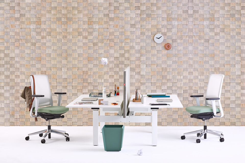 Gispen TM dual table with white frame and white tabletop  and 2 Zinn office chairs and green Binit wastebin in front of light brown pattern background front view
