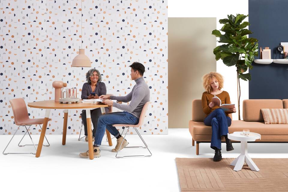 Gispen NOMI project chair with red upholstered cover and TEAM Wood round with STEE sofa in hospitality setting with models front view