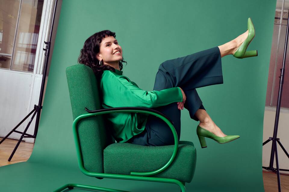 Gispen Classics 407 armchair in green on green backdrop with female model coffee roastery at Van Nelle factory front left detail view