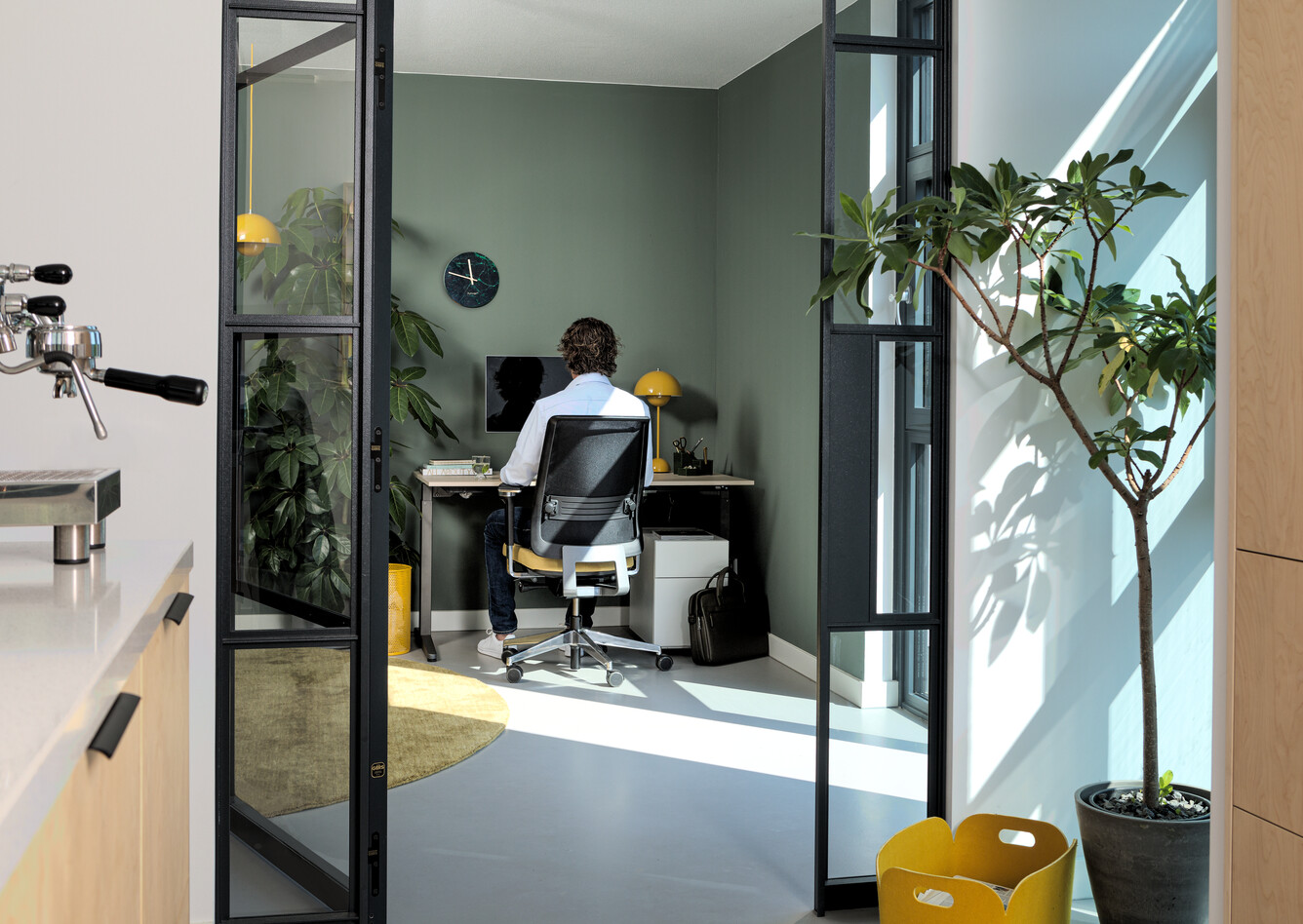 Royal Ahrend balance workstation in grey with oak tabletop and Ease office chair upholstered in yellow and black with male model interior view