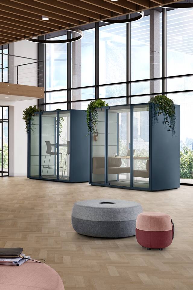 Qabin Chat Connect high, Qabin Chat Lounge, Well, Recharge 165, Recharge 100, Recharge 45 Ahrend Qabin Chat Connect high and Chat Lounge space in space in carbon blue with 3 Recharge poufs in a vitalising workspace interior view