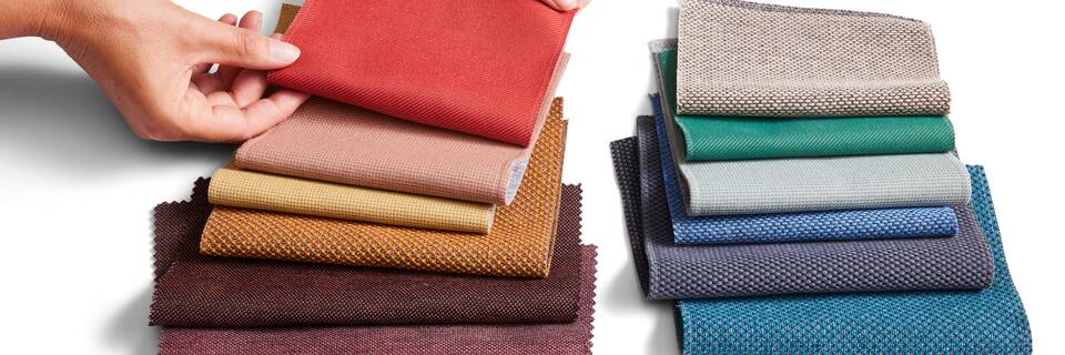 Royal Ahrend sustainable red and blue fabric selection with hands front top view