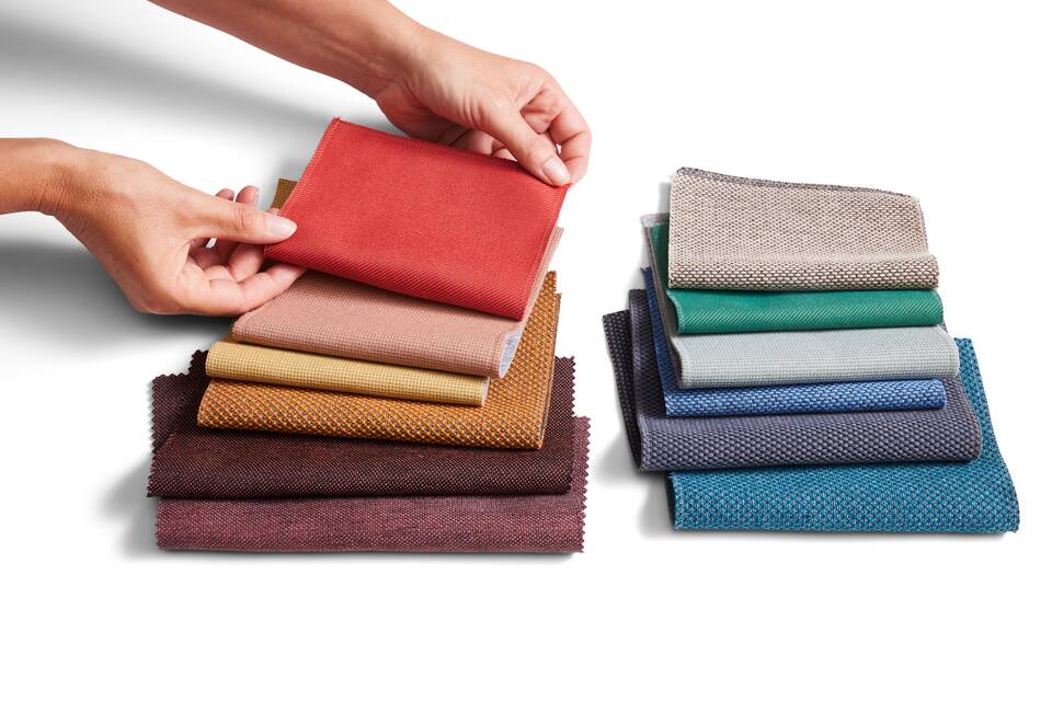 Royal Ahrend sustainable red and blue fabric selection with hands front top view