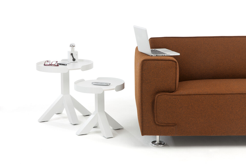 Gispen Dukdalf round small and large side tables in white with Switch table lamp next to brown sofa with laptop on it front view