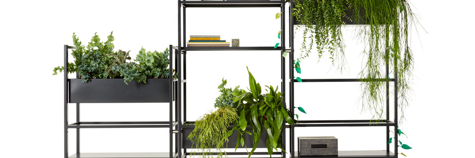 Gispen CIMO shelving unit in black with planters and plants and Outline clock and green Dombo cup front view